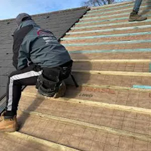 a man working on the roof of a house