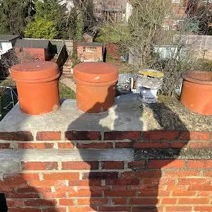 a brick wall with three clay pots on top of it